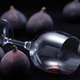 Figs surrounding empty overturned glass of red wine